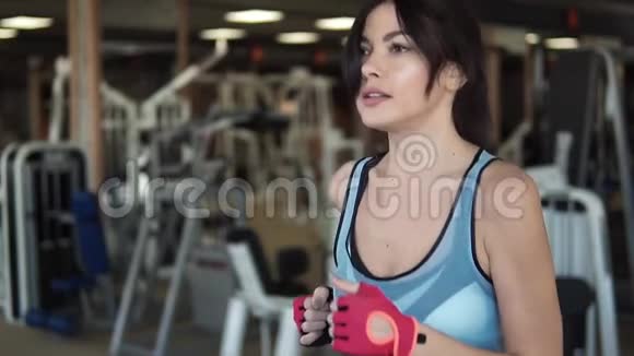 在健身房跑步机上跑步的女孩做有氧运动的年轻女人在健身房锻炼跑步机视频的预览图