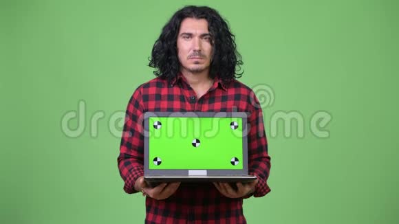 英俊的时髦男人展示笔记本电脑视频的预览图
