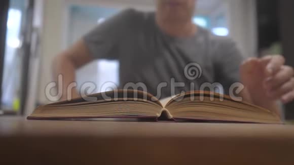 男人正在看一本书慢镜头教育学习图书馆理念男人打开书男人翻页视频的预览图