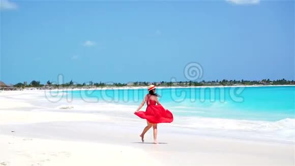 年轻漂亮的女人在白色的热带海滩度假在海边散步的女孩慢动作视频的预览图