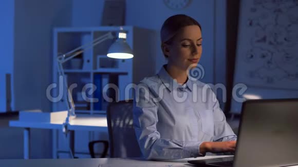 带笔记本电脑的女商人在夜间办公视频的预览图