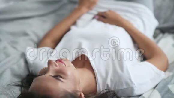 漂亮的年轻女人躺在床上视频的预览图