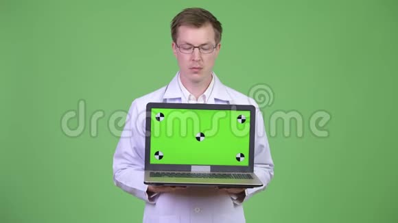 快乐男医生展示彩色钥匙绿色屏幕笔记本电脑视频的预览图