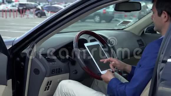 商人拿着平板电脑坐在车里视频的预览图
