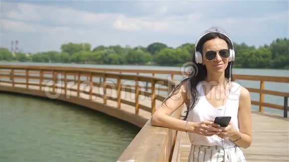 快乐的年轻都市女性享受户外音乐视频的预览图