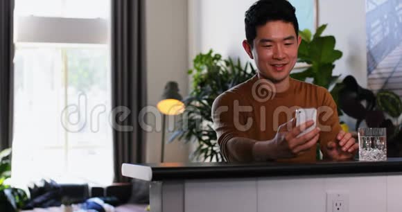 男人在厨房用手机视频的预览图
