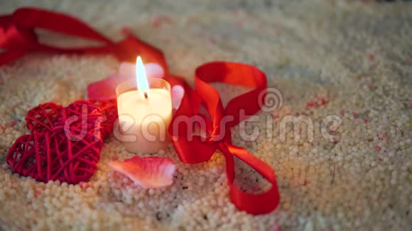 情人节的装饰画丝带和蜡烛在沙子上燃烧视频的预览图