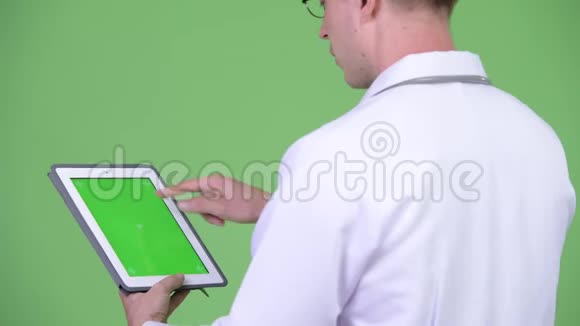 使用带有彩色键绿色屏幕的数字平板电脑的男医生视频的预览图