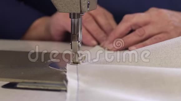 家具厂里一位正在为沙发缝制材料的老妇人的特写镜头视频的预览图
