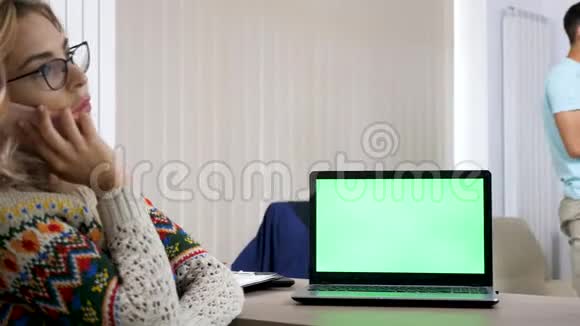 客厅桌子上有绿色屏幕的电脑视频的预览图