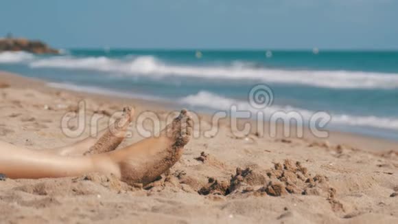 躺在海边的沙滩上的女人的腿视频的预览图