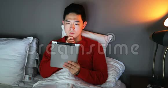 男子4k床上使用数码平板电脑视频的预览图