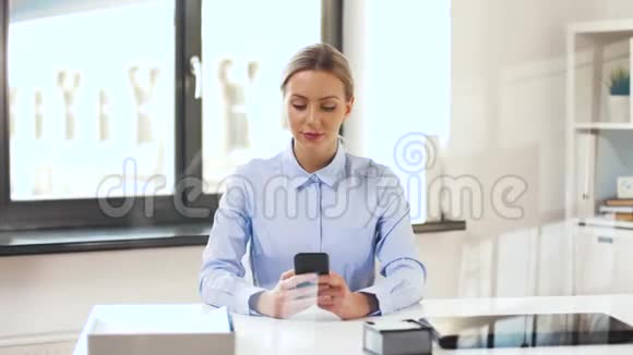 有智能手机的女商人在办公室工作视频的预览图