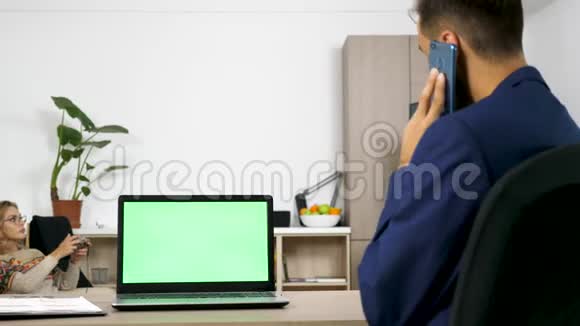客厅桌子上有绿色屏幕的笔记本电脑视频的预览图