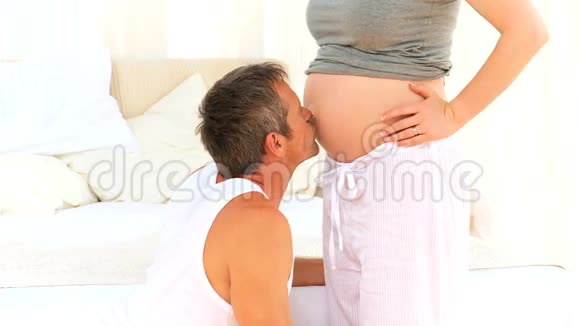 男性亲吻怀孕妻子的腹部视频的预览图