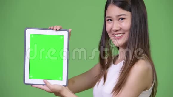 年轻漂亮的亚洲女商人展示数码平板电脑视频的预览图