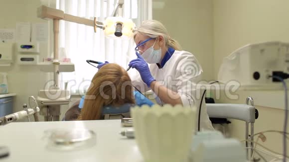 在牙科办公室工作的年轻女牙医视频的预览图