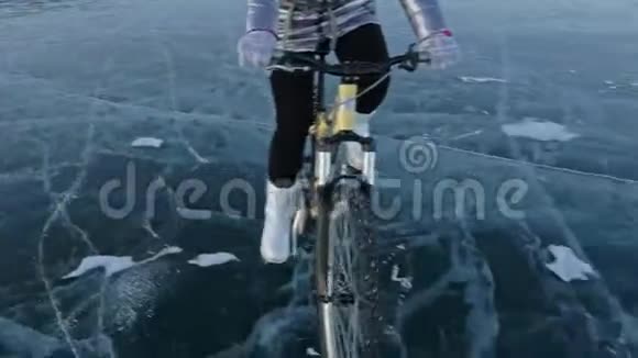 女人在冰上骑自行车女孩穿着银色羽绒服自行车背包和头盔冰冰视频的预览图