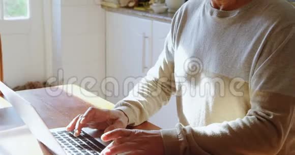 厨房用笔记本电脑的老人视频的预览图