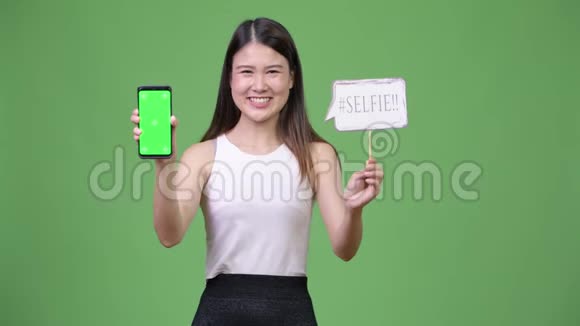 年轻漂亮的亚洲女商人展示电话视频的预览图