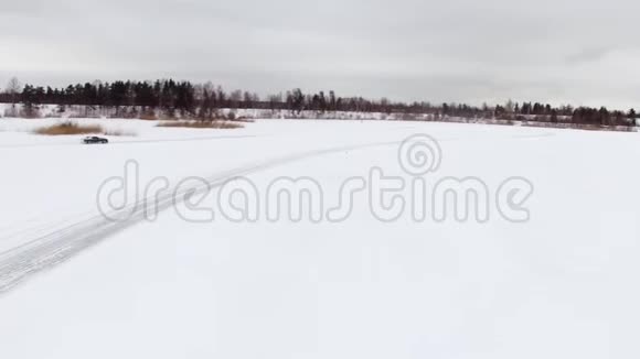 冬天在雪覆盖的湖面上汽车在结冰的轨道上行驶空中观景冬季雪地赛道上的赛车视频的预览图