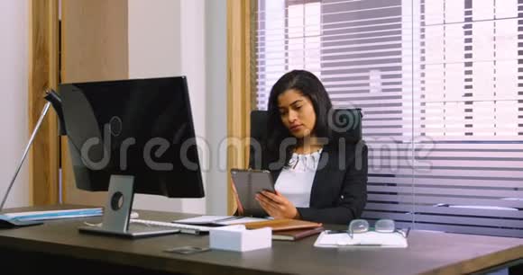 办公桌4k上使用数码平板电脑的女性高管视频的预览图