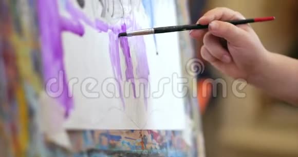 年轻的艺术家的手小女人艺术家用画笔画一幅画布坐在桌子上画画布程序视频的预览图