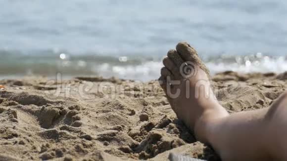躺在海边的沙滩上的女人的腿视频的预览图