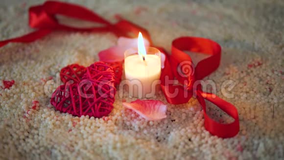 情人节的装饰画丝带和蜡烛在沙子上燃烧视频的预览图