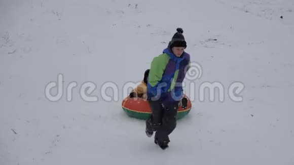 冬天的雪乐趣孩子们从滑梯上骑着一根管子视频的预览图