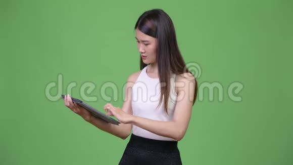 年轻漂亮的亚洲商人使用数码平板电脑视频的预览图