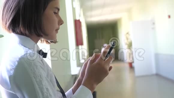 生活方式女学生教育与智能手机在学校的概念十几岁的少女和使用智能手机站在旁边视频的预览图