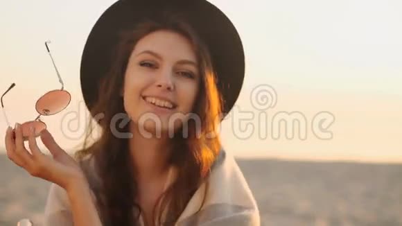 日落时海滩上美丽年轻女子的肖像视频的预览图