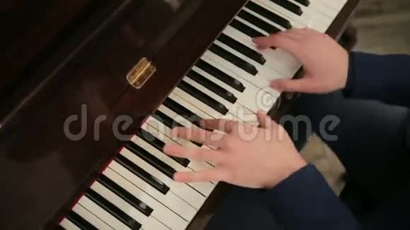 穿着蓝色西装的钢琴家在钢琴上演奏得很快视频的预览图