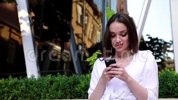 在办公大楼附近街道使用手机的妇女视频的预览图