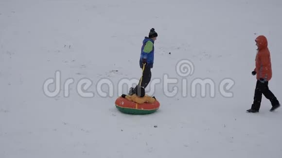 冬天的雪乐趣孩子们从滑梯上骑着一根管子视频的预览图