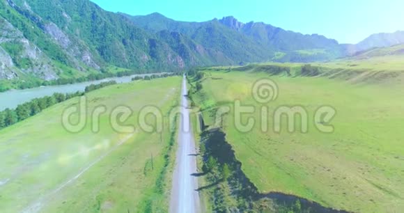 阳光明媚的夏季早晨空中乡村山路和草地沥青公路和河流视频的预览图