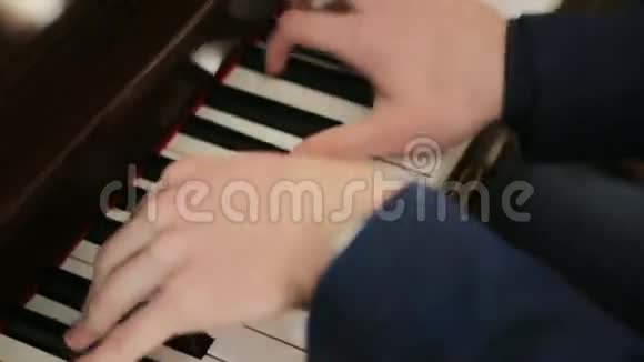 穿着蓝色西装的钢琴家在钢琴上演奏得很快视频的预览图