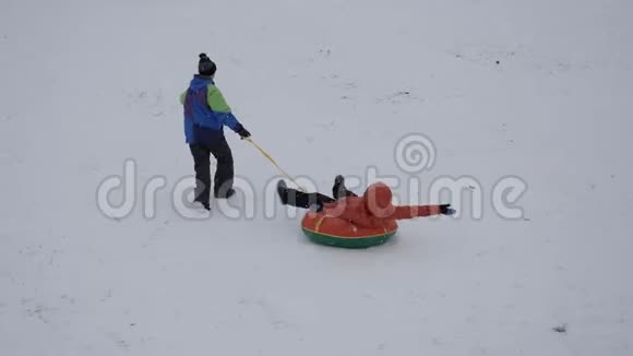 冬天的雪乐趣孩子们从滑梯上骑着一根管子视频的预览图