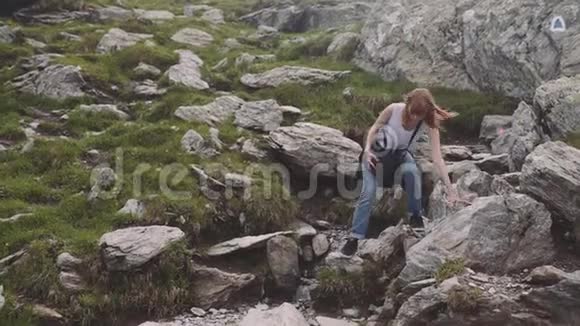一个年轻的女徒步旅行者带着照片相机爬山罗马尼亚喀尔巴阡山脉视频的预览图