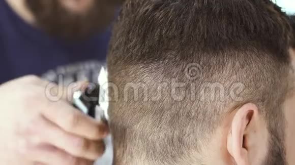 职业造型师用电动剃须刀给理发店的客户做发型视频的预览图