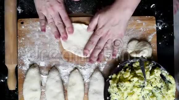 木板背景上有土豆的面团和生馅饼视频的预览图