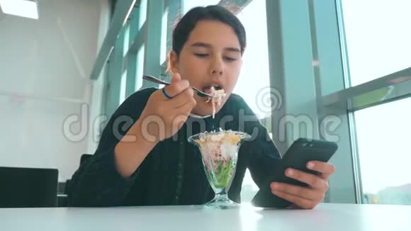 机场等待飞机航班十几岁的女孩吃沙拉看上去像智能手机的生活方式在咖啡馆里上网机场视频的预览图