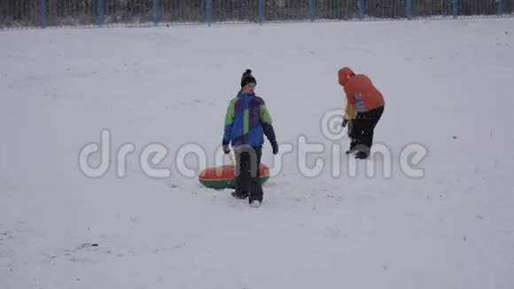 冬天的雪乐趣孩子们从滑梯上骑着一根管子视频的预览图