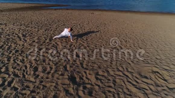 女人在城市河边的沙滩上做瑜伽美丽的景色视频的预览图