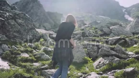 一个年轻的女徒步旅行者带着照片相机爬山罗马尼亚喀尔巴阡山脉视频的预览图