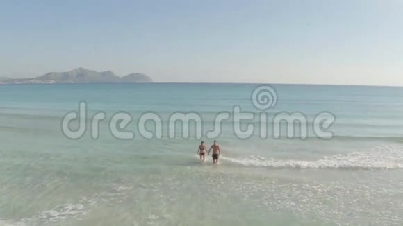年轻夫妇在海滩上玩视频的预览图