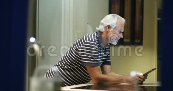 在家使用数字平板电脑的老人4k视频的预览图