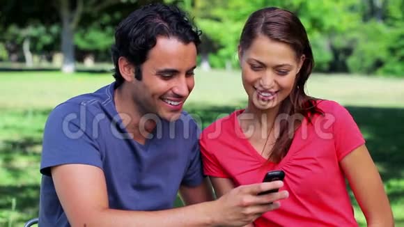 一对微笑的夫妇在看手机短信视频的预览图