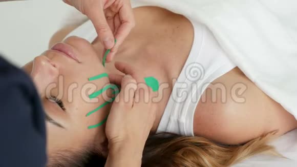 医生美容师在躺着的病人脸上贴胶带视频的预览图